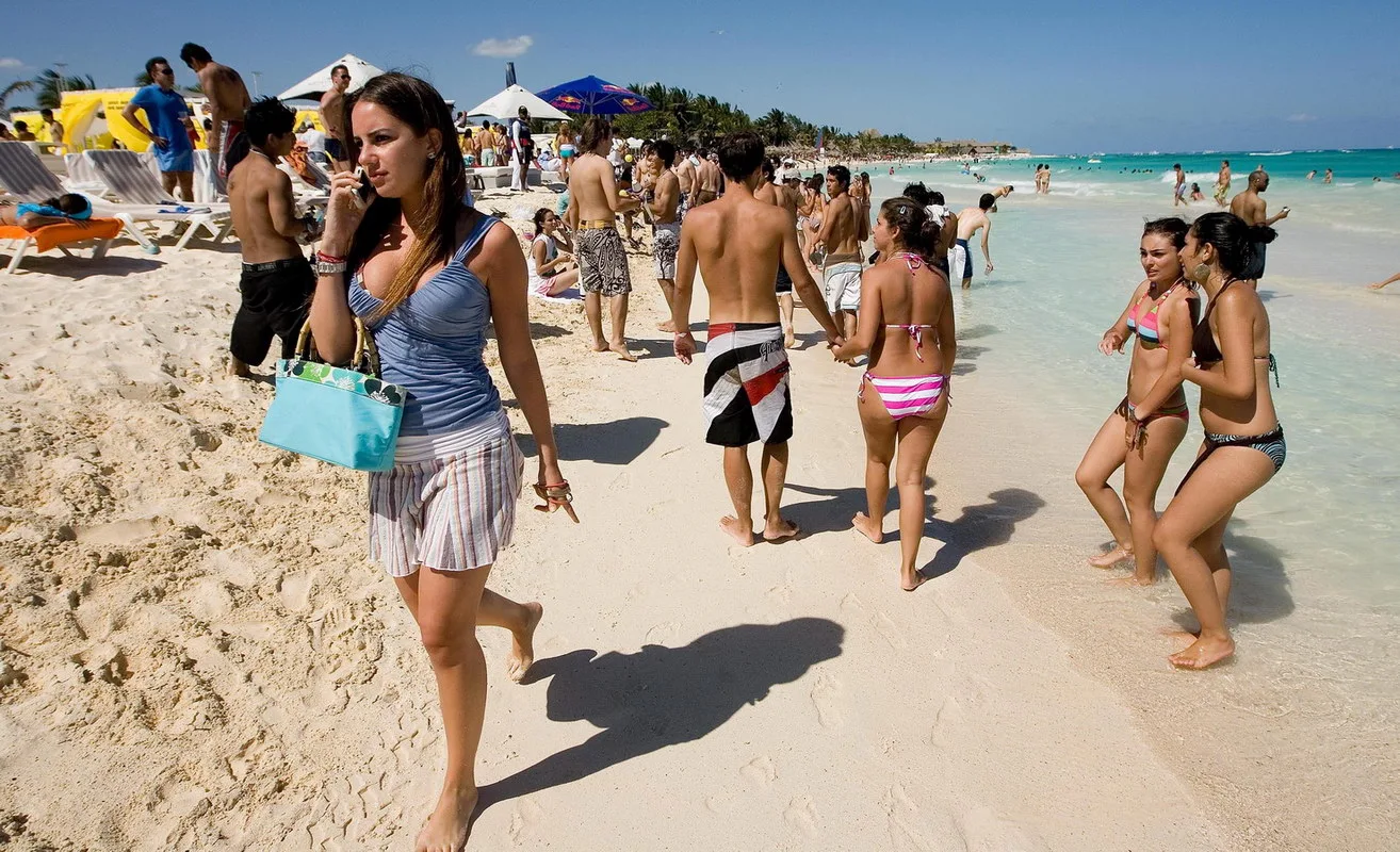 A view of a beach in Cancun, Quintana Roo, with turquoise waters and palm trees