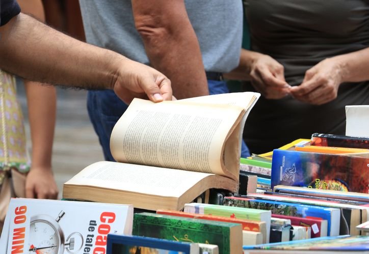 A promotional image for the Cancún Book Fair, showing books and cultural displays
