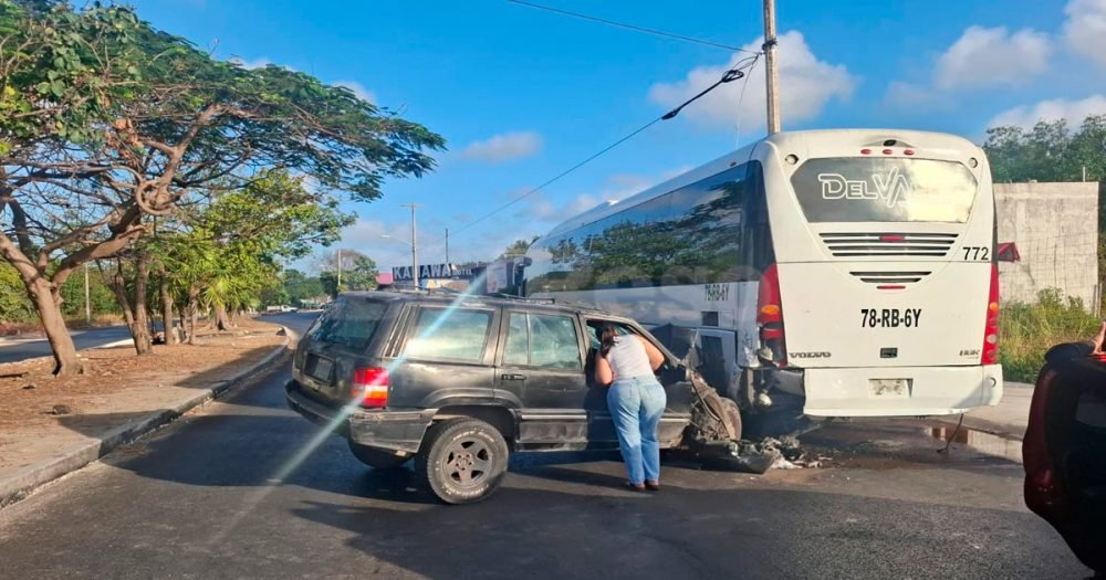 A black Jeep Grand Cherokee SUV with severe front-end damage after crashing into a bus on Kabah Avenue in Cancún