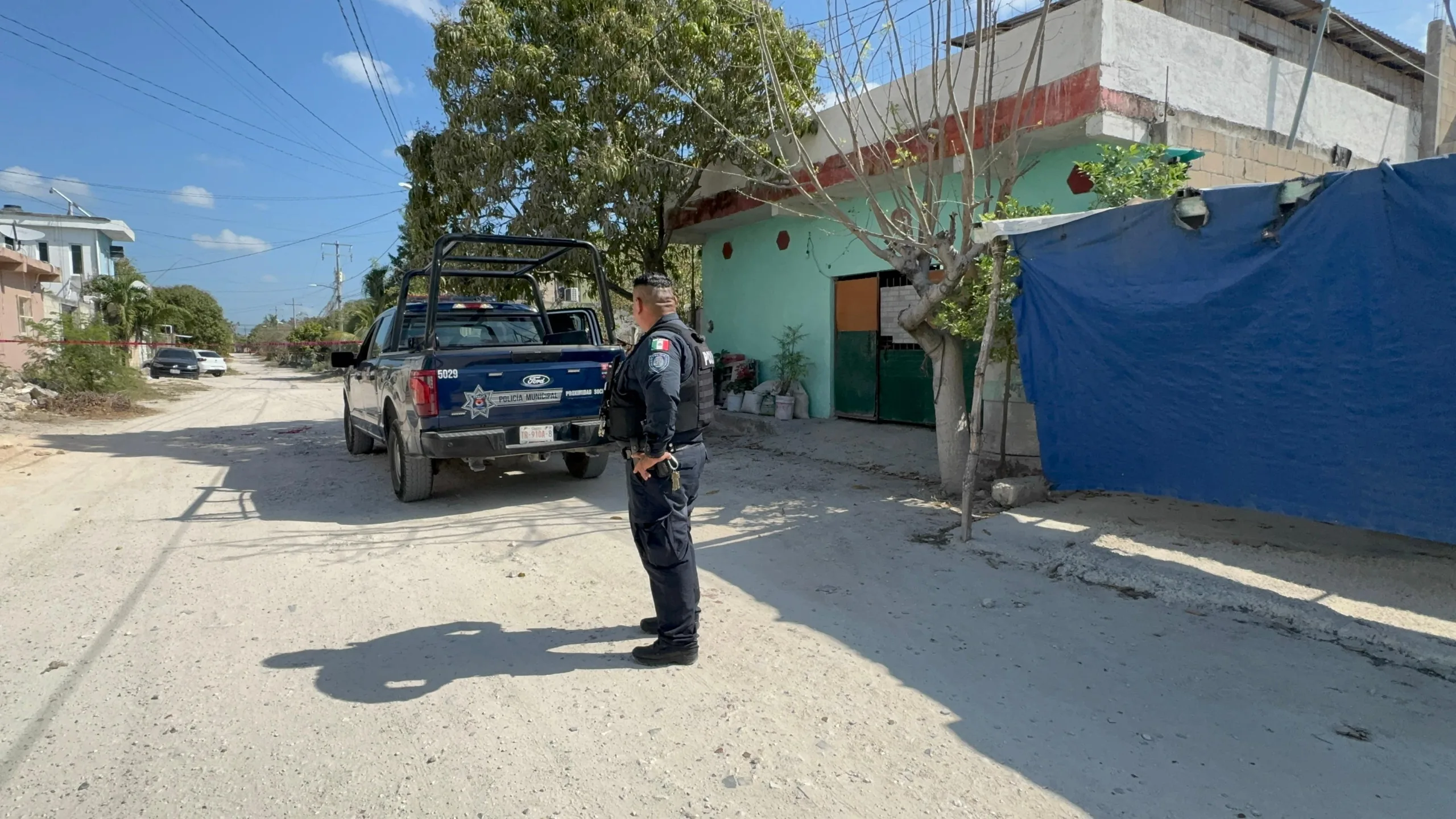 Police and forensic investigators at the scene where a man was found dead in a home in Cancún's Region 244