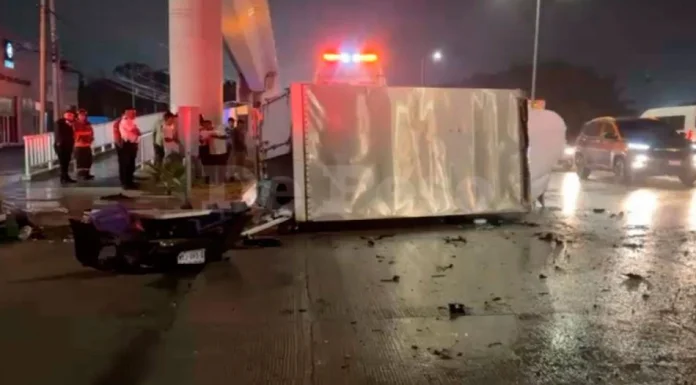 A refrigerated truck overturned on its side on a wet road near Cancun International Airport