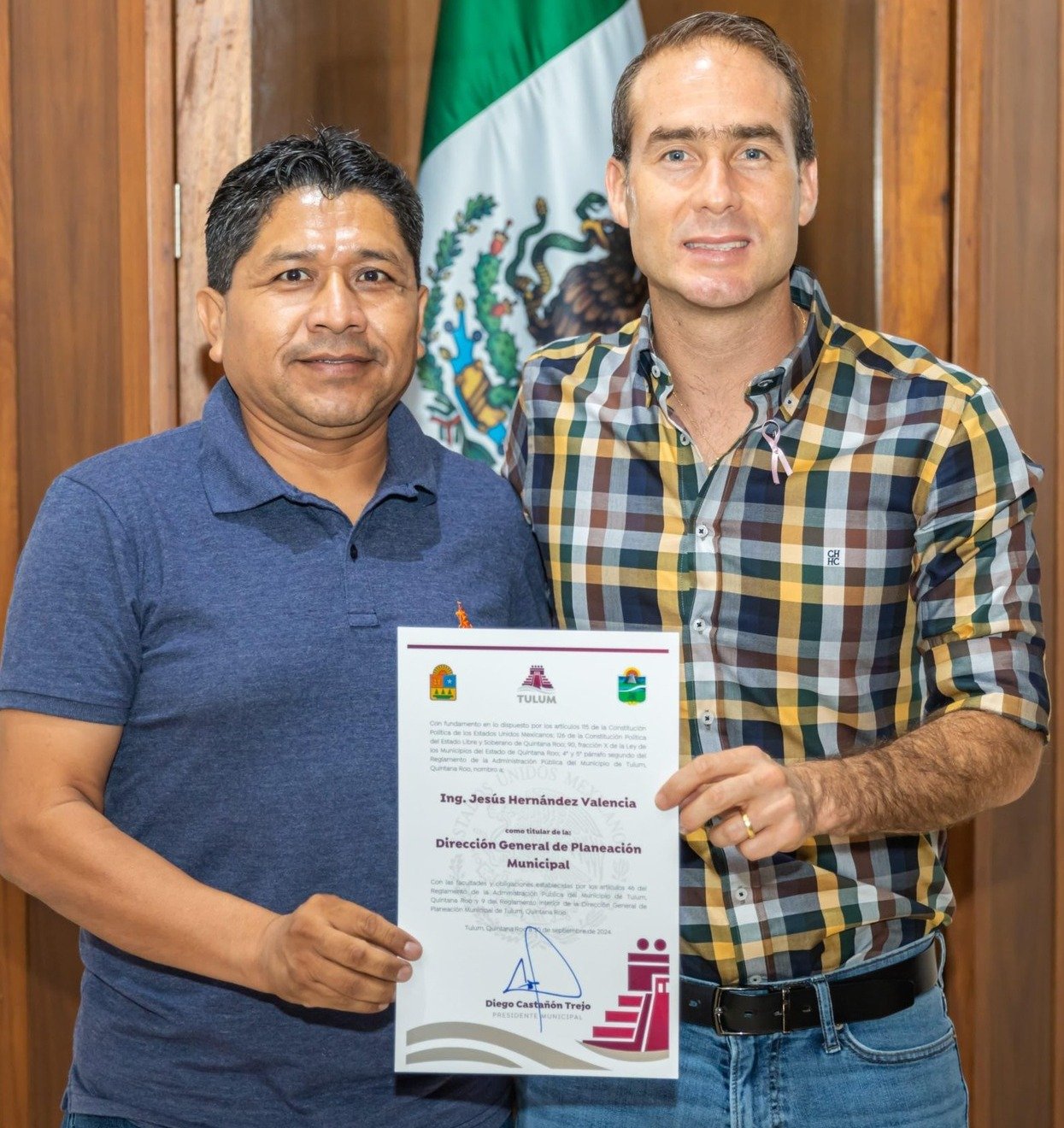 A moment from the certificate awarding ceremony in Tulum, as two officials celebrate a significant achievement together.