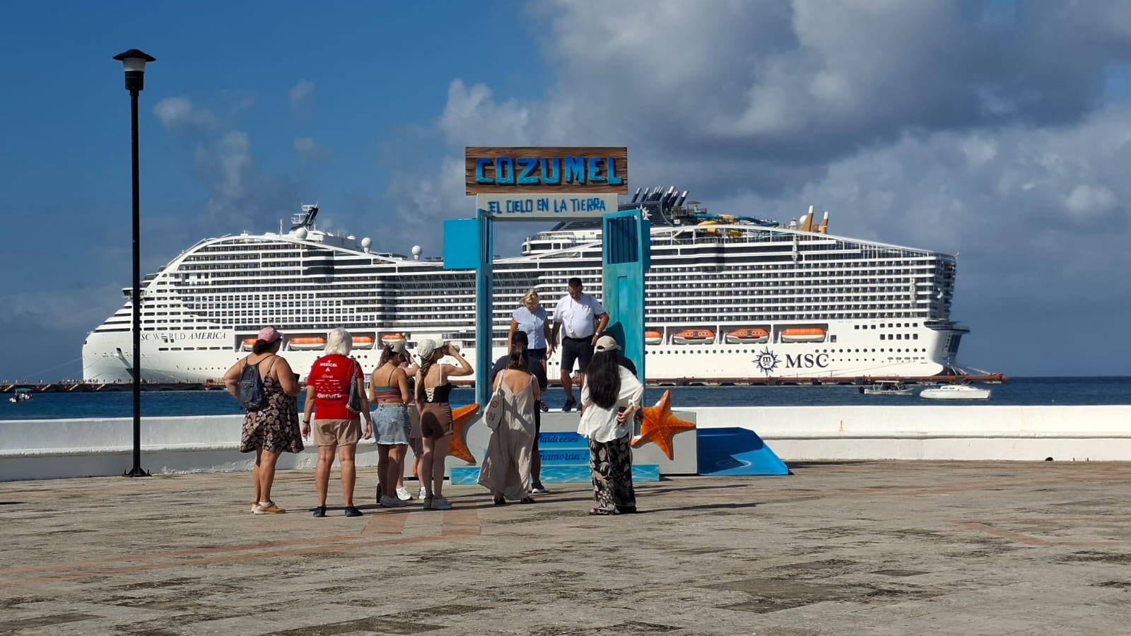 A cruise ship docked at the port of Cozumel, Mexico, with passengers disembarking