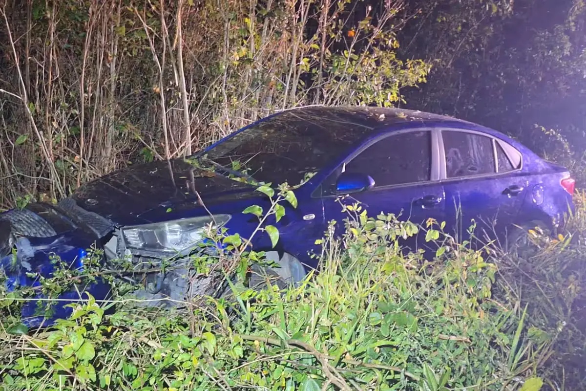 A blue Kia Rio sedan with significant damage after veering off Highway 184 near Felipe Carrillo Puerto