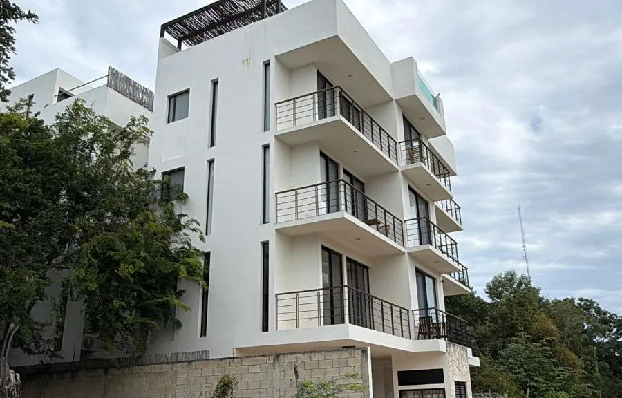 An elderly woman holding documents, representing the fraud victim in Tulum