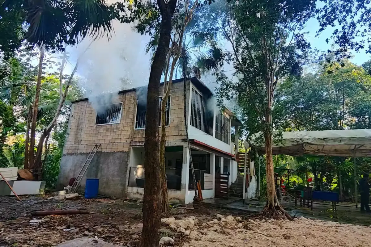 Firefighters in protective gear working to extinguish a fire inside a residential building in Puerto Morelos