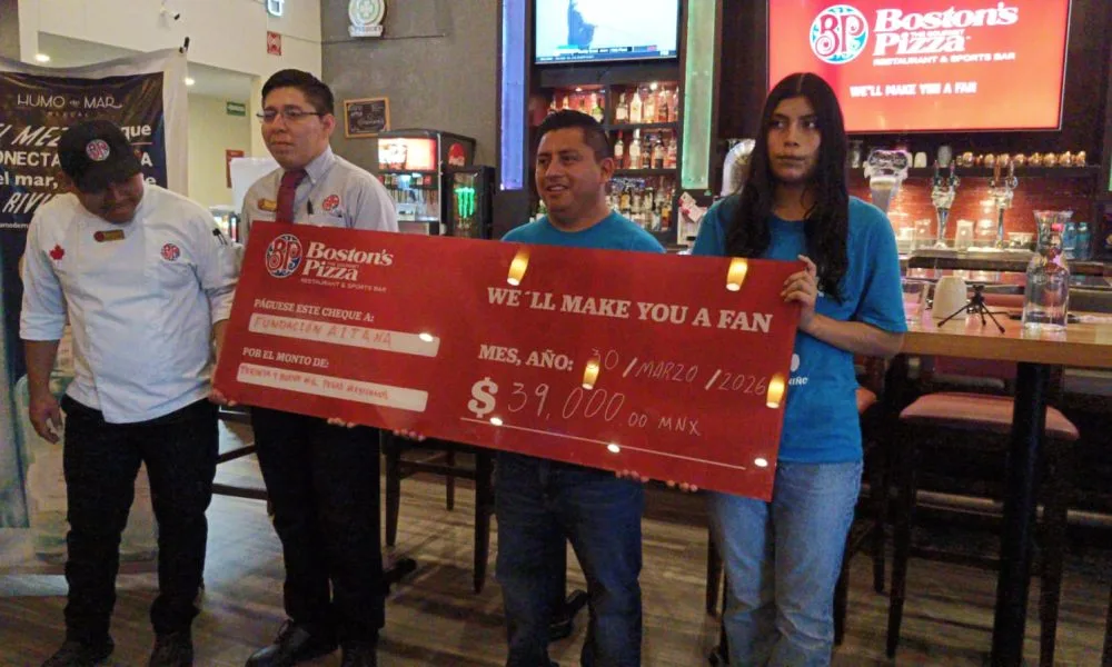 A symbolic check for 39,000 pesos is presented to representatives of Fundación Aitana in Playa del Carmen.