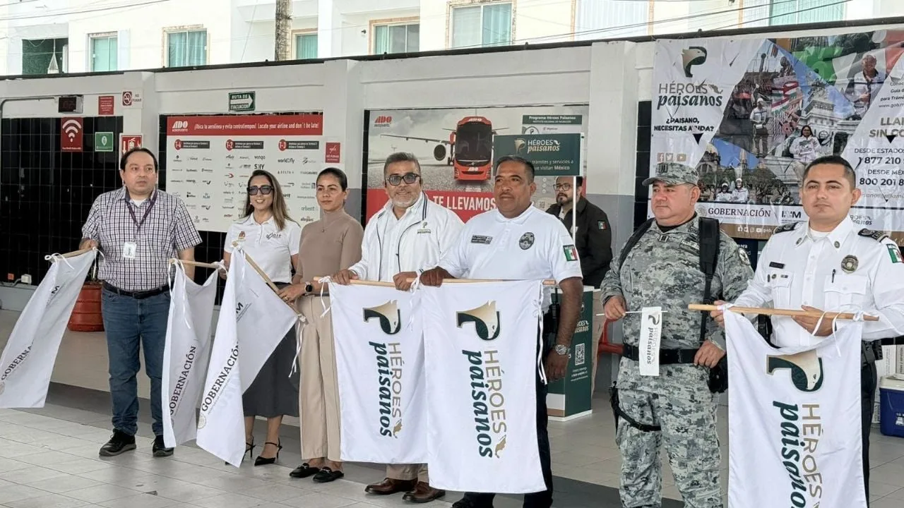 Officials stand at the ADO bus terminal in Playa del Carmen during the launch of the Héroes Paisano program.