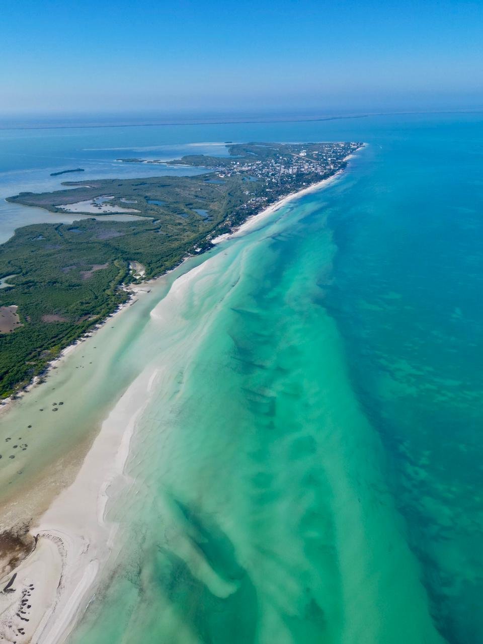 A view of a beachfront hotel in Holbox, Mexico, with sandy streets and coastal scenery