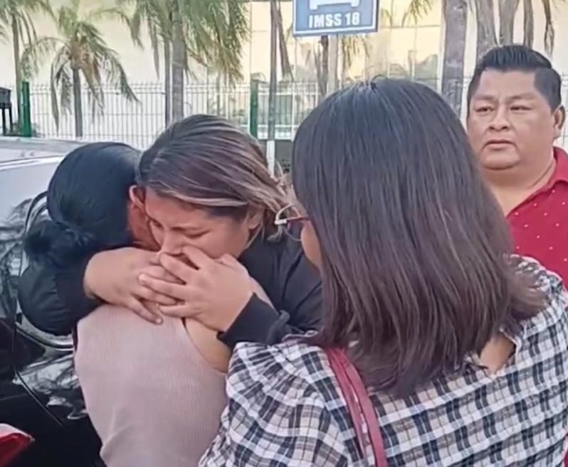 A nurse in medical scrubs standing outside a hospital building
