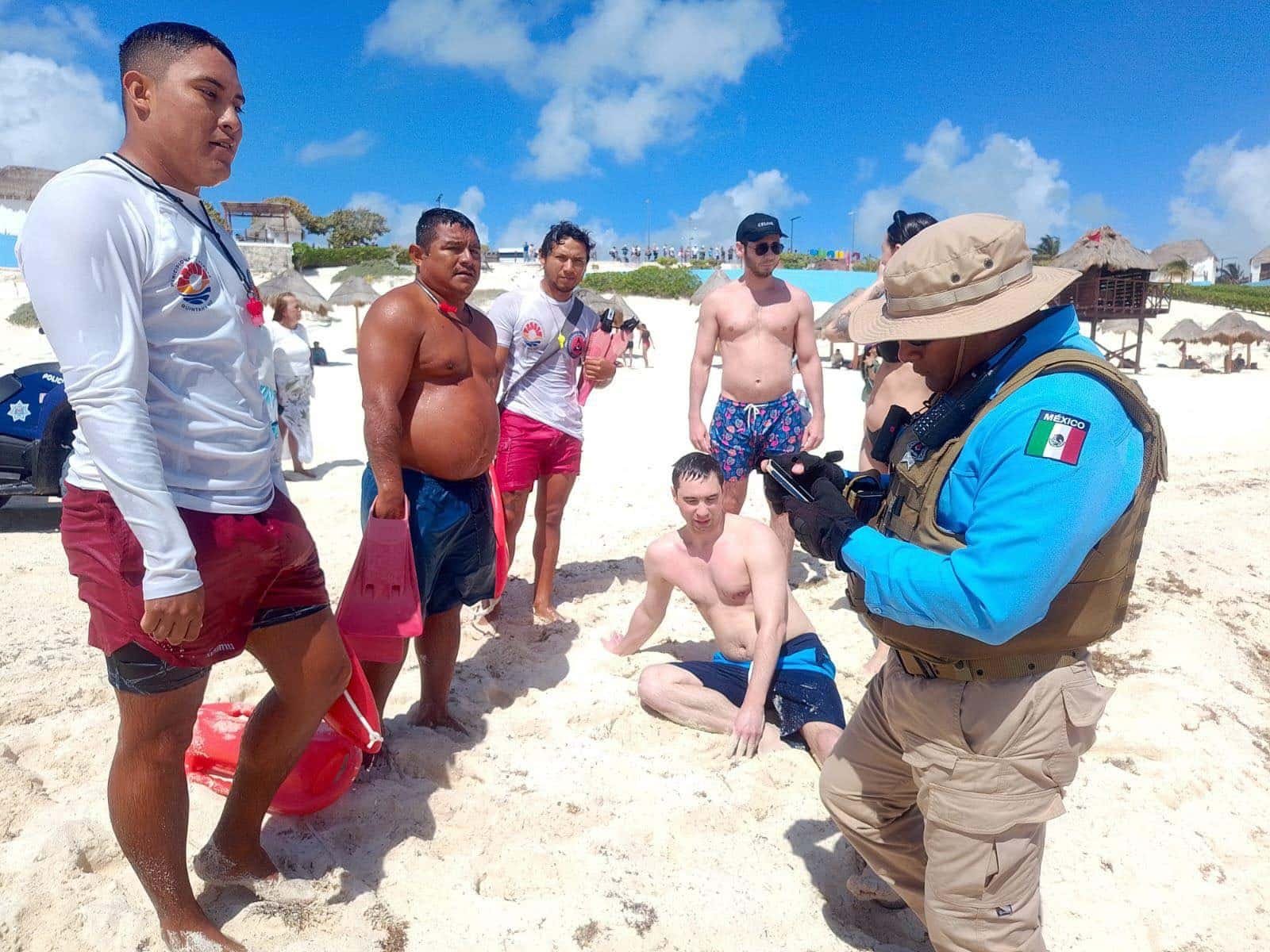 Lifeguards performing a rescue operation at Playa Delfines beach in Cancún, Mexico