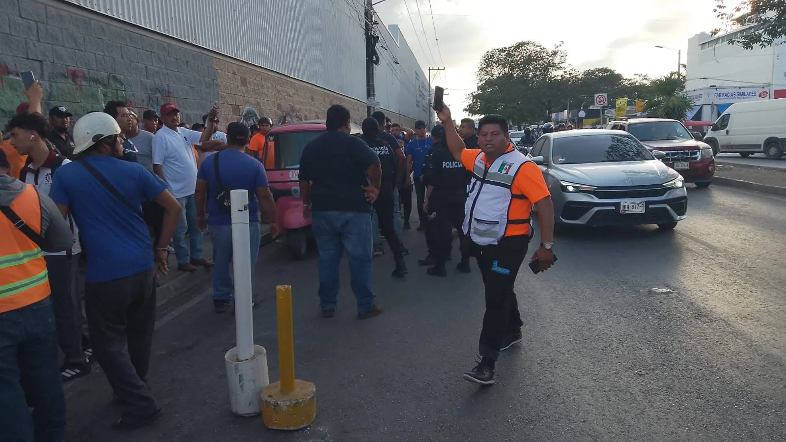Police officers intervene as mototaxi drivers from rival unions fight on a street in Cancún
