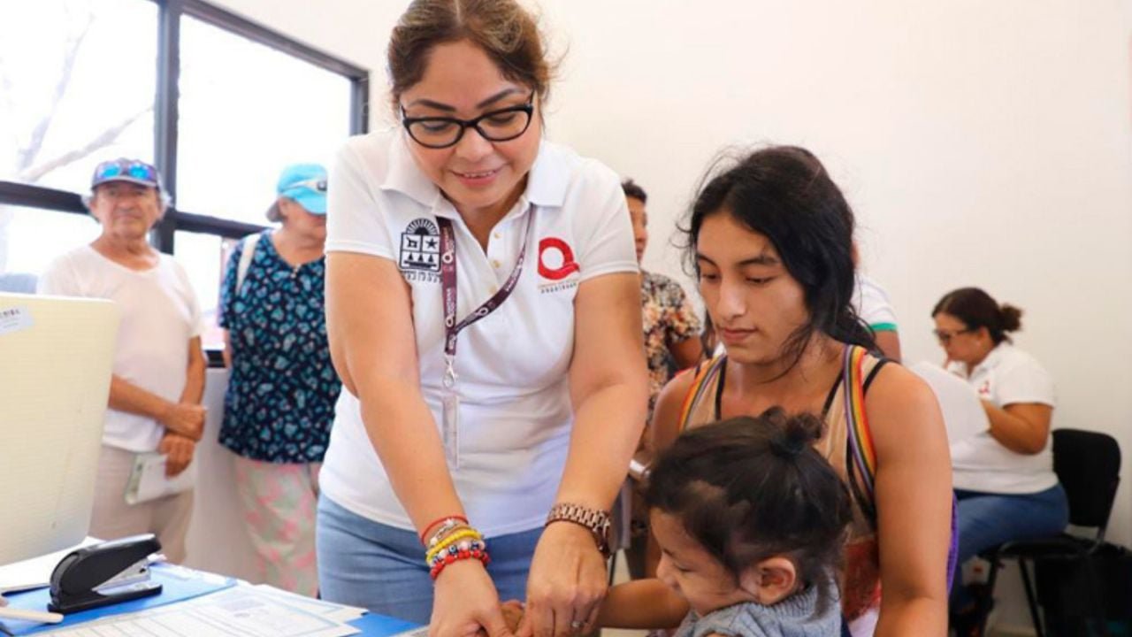 Officials assisting residents with identity documents at a community event in Playa del Carmen