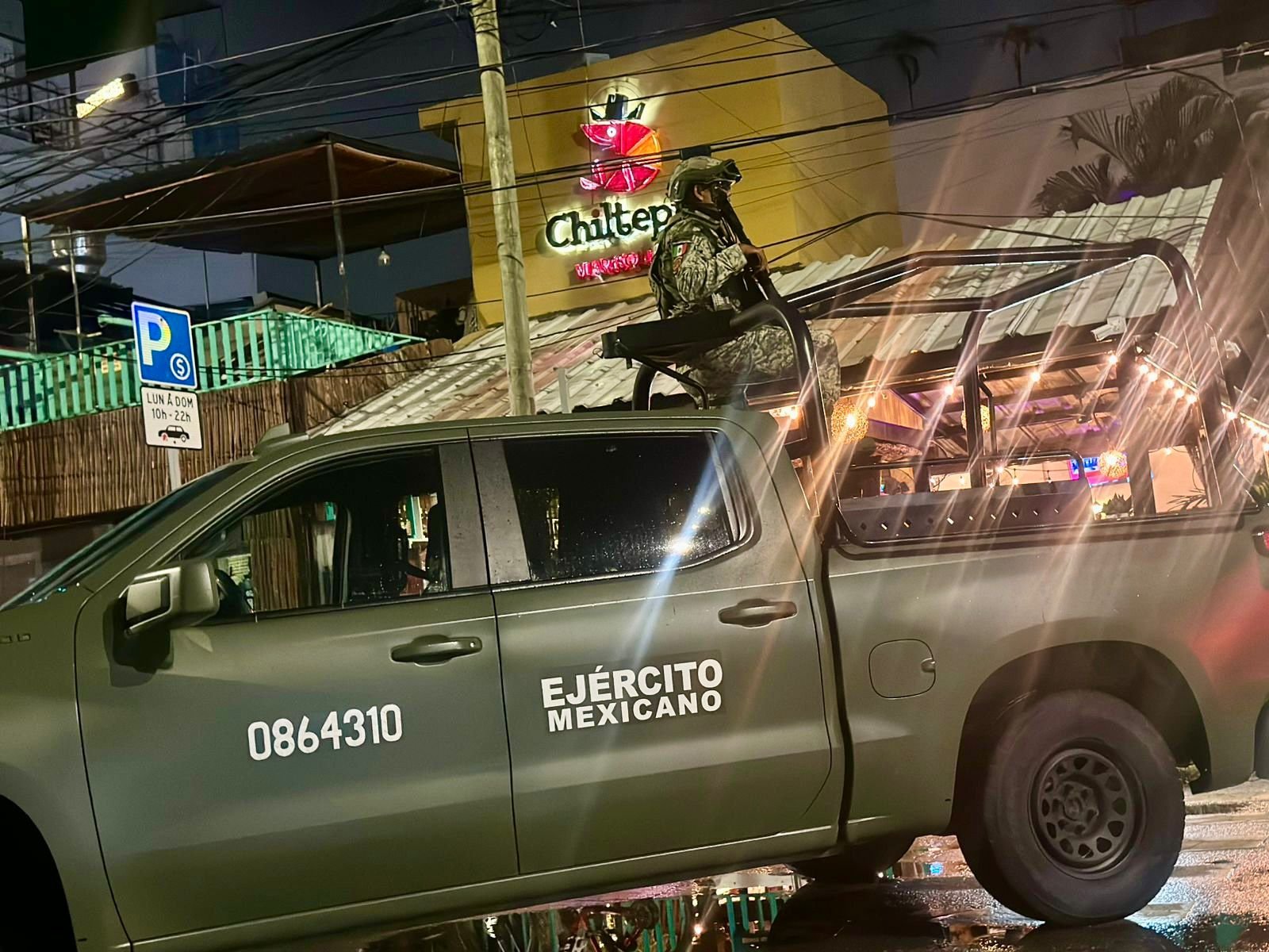 Security personnel and vehicles on a street in Playa del Carmen during a nighttime operation