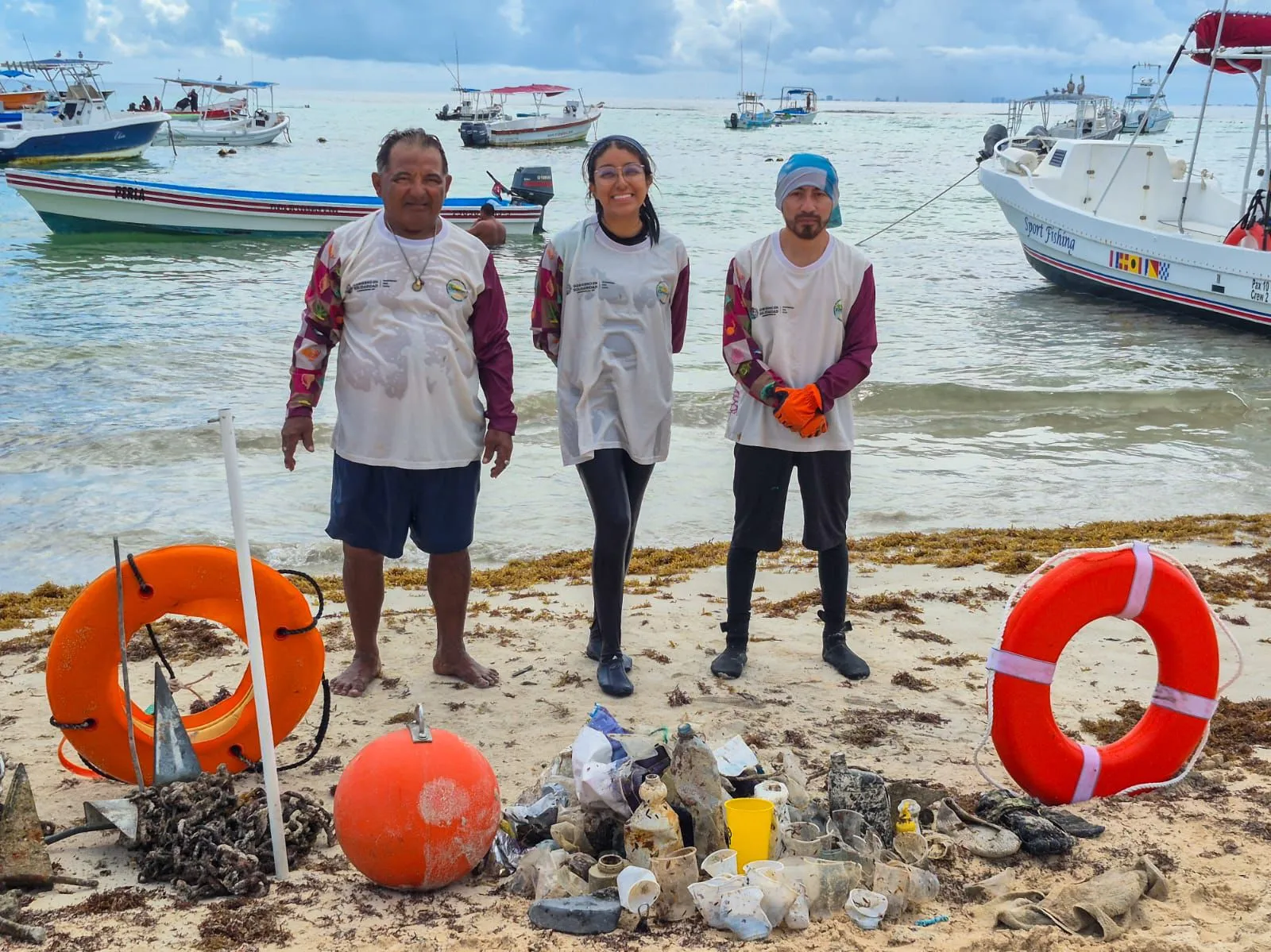 Workers collecting debris from the ocean floor during a marine cleanup operation in Playa del Carmen