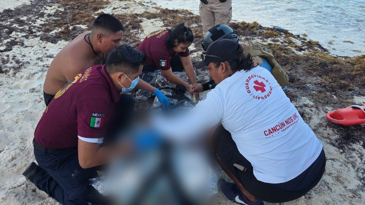 Emergency responders and lifeguards assisting a rescued swimmer on Gaviota Azul beach in Cancún's Hotel Zone
