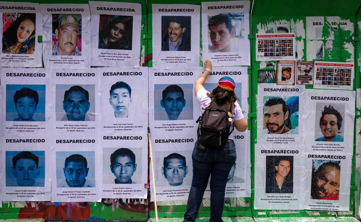Members of collectives and relatives of missing persons place posters at the Glorieta de las y los Desaparecidos monument in Mexico City.