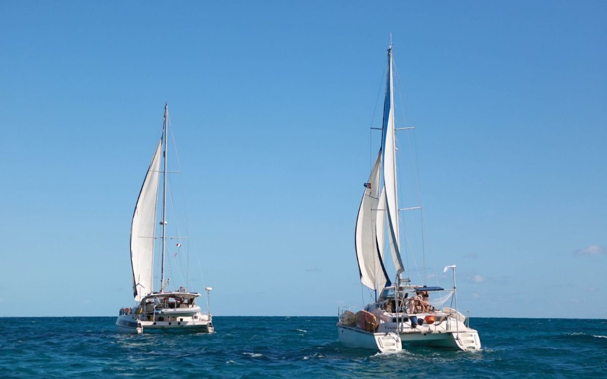 Illustration of sailboats in the Caribbean Sea with search aircraft overhead