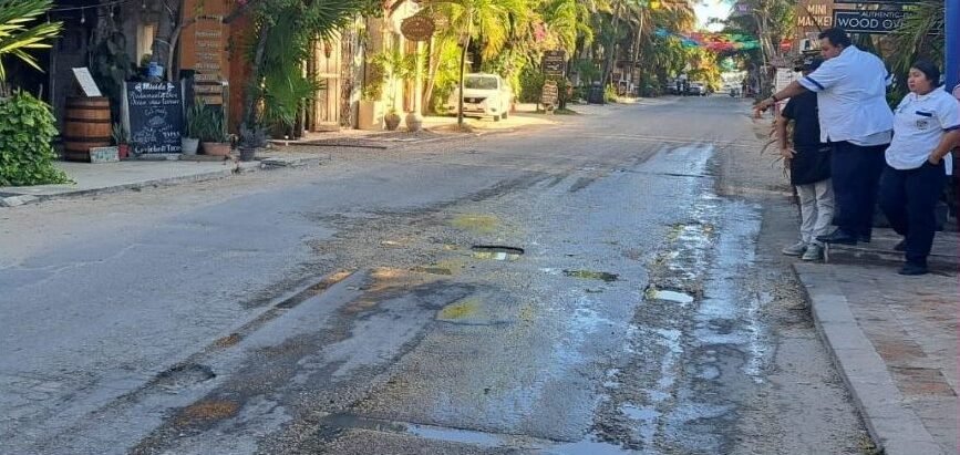 A section of Tulum's coastal highway showing potholes and deteriorating pavement