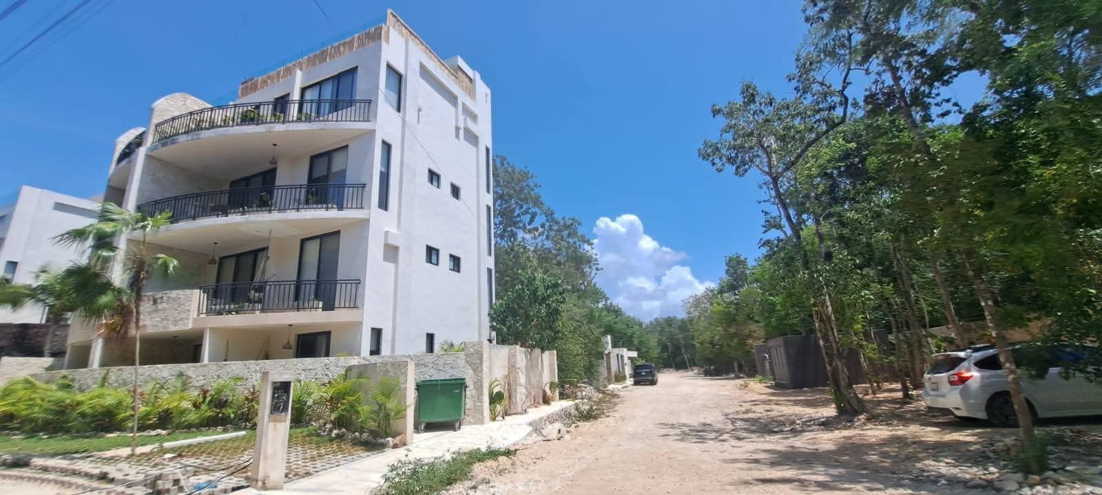 Aerial view of Tulum's coastline with construction cranes and buildings in the background