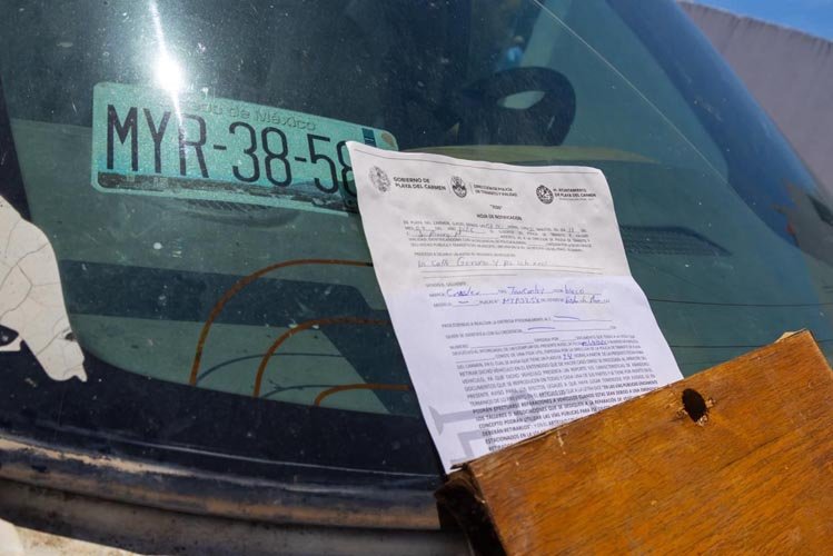 Authorities in Playa del Carmen removing abandoned vehicles from a residential street