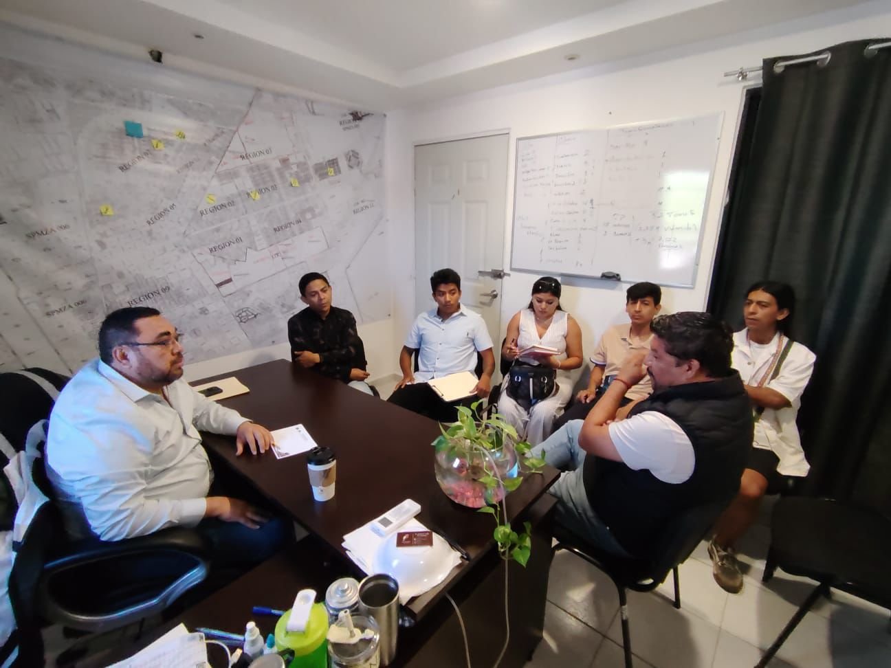 Community members and officials gathered at a meeting table in Akumal, Quintana Roo