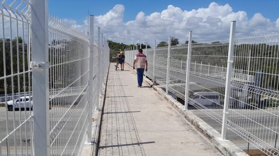Workers performing maintenance on the pedestrian bridge in Akumal, Quintana Roo