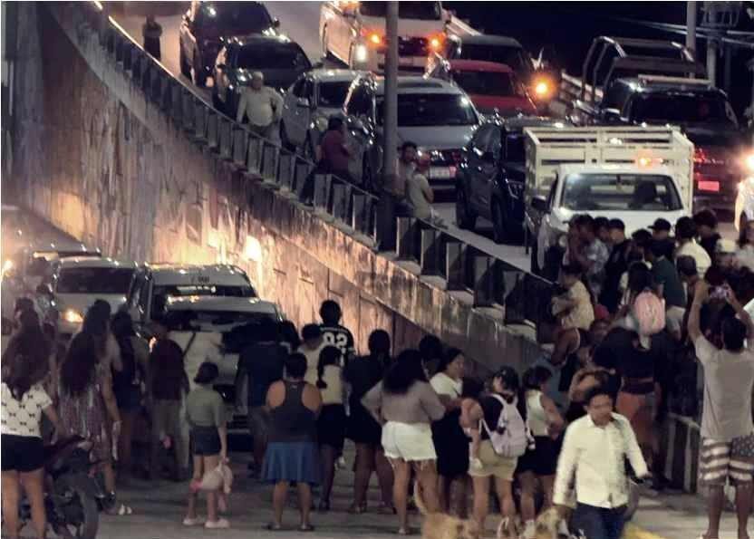 Residents block a road in Akumal with rocks and signs during a protest