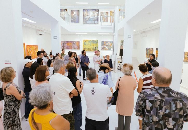 Artist Armando Martínez stands in front of his artwork at the Playa del Carmen gallery.