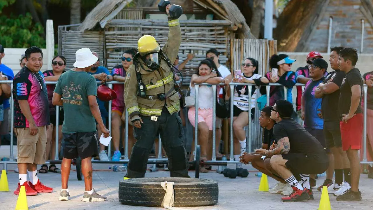 Firefighters and CrossFit athletes competing in full gear on the boardwalk in Isla Mujeres