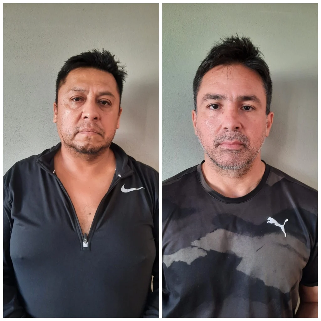 Belize police officers standing near a seized aircraft used for drug trafficking