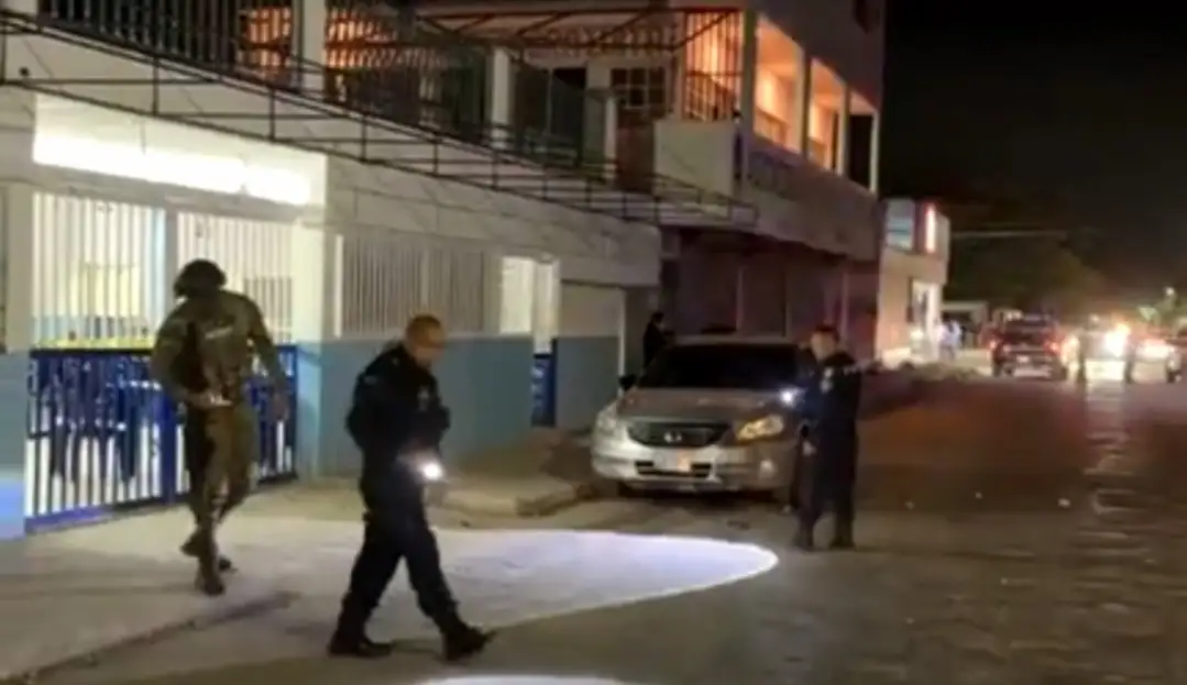Police officers and forensic investigators at the scene of a shooting outside a bar in Cancún, Mexico