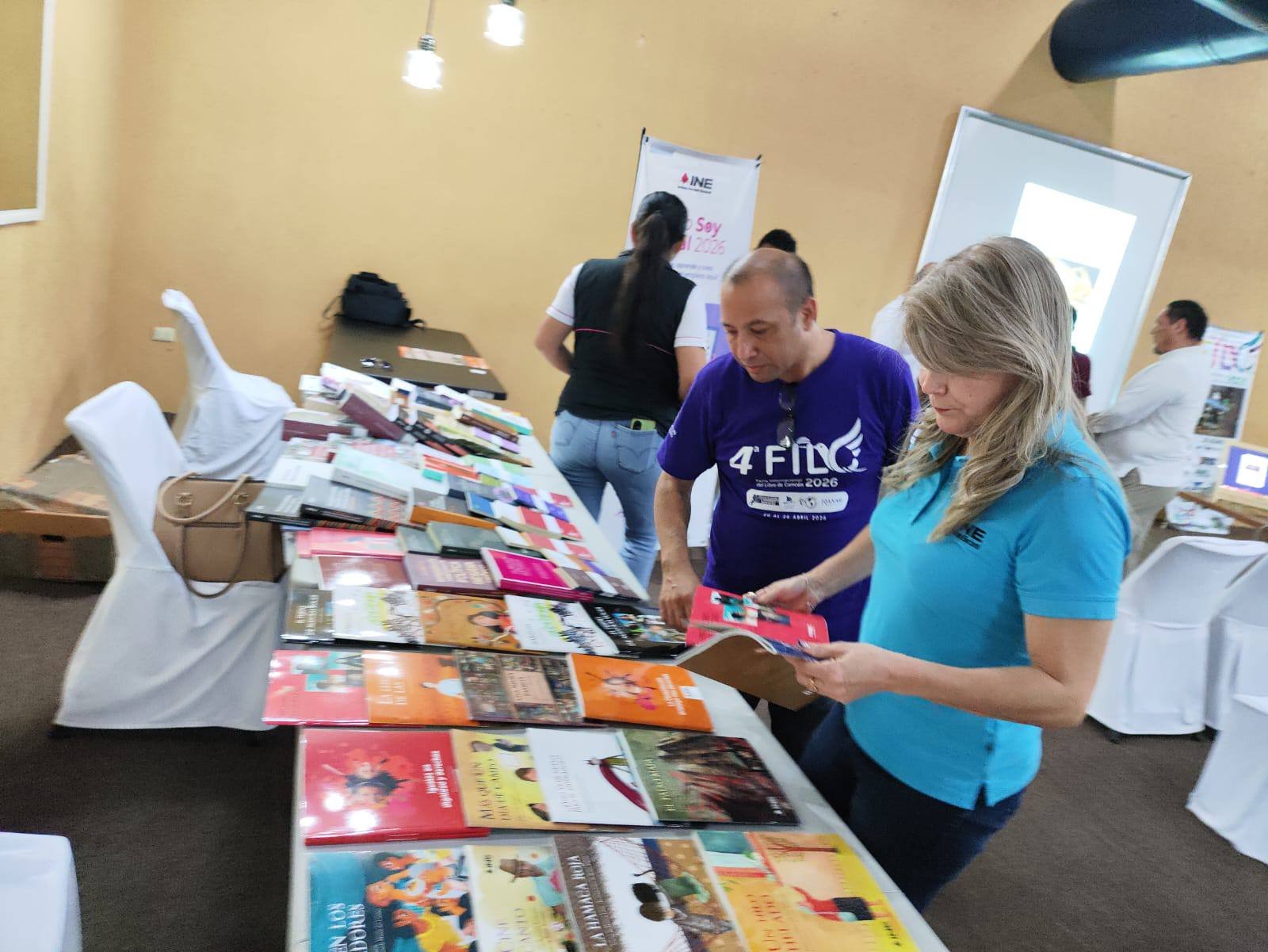 People browsing books at the Cancún International Book Fair inside Hotel Plaza Caribe