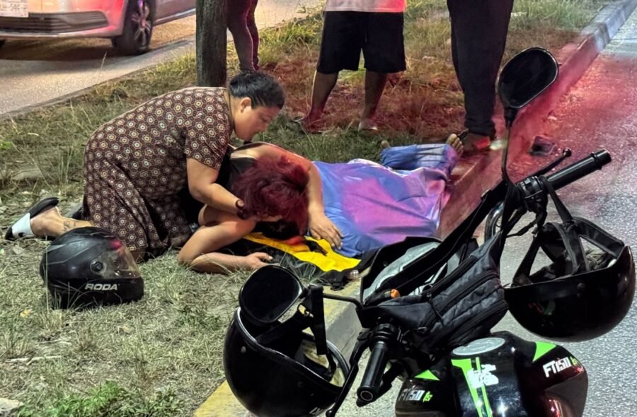 Police tape cordoning off a motorcycle accident scene on a road in Cancun at night