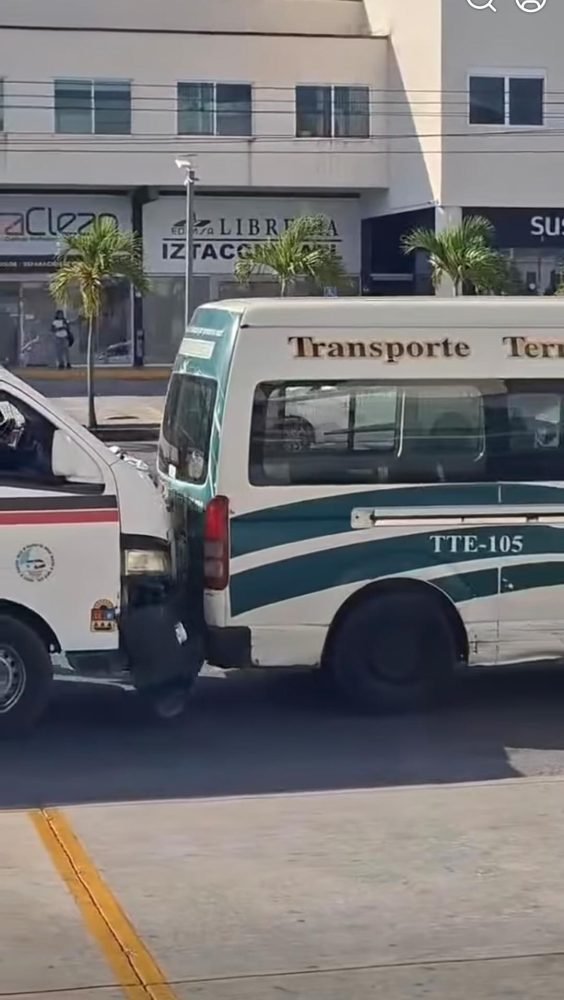 Two Cancun public bus drivers fighting on a busy avenue, one holding a tire iron