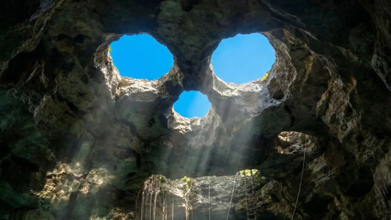 Aerial view of Cenote Calavera in Tulum showing its distinctive skull-shaped formation with three circular openings
