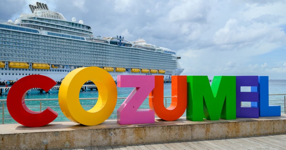 A cruise ship docked at Cozumel, Mexico, with turquoise waters in the foreground