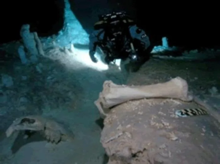 Divers at the entrance of the Hoyo Negro cenote in Tulum, Quintana Roo