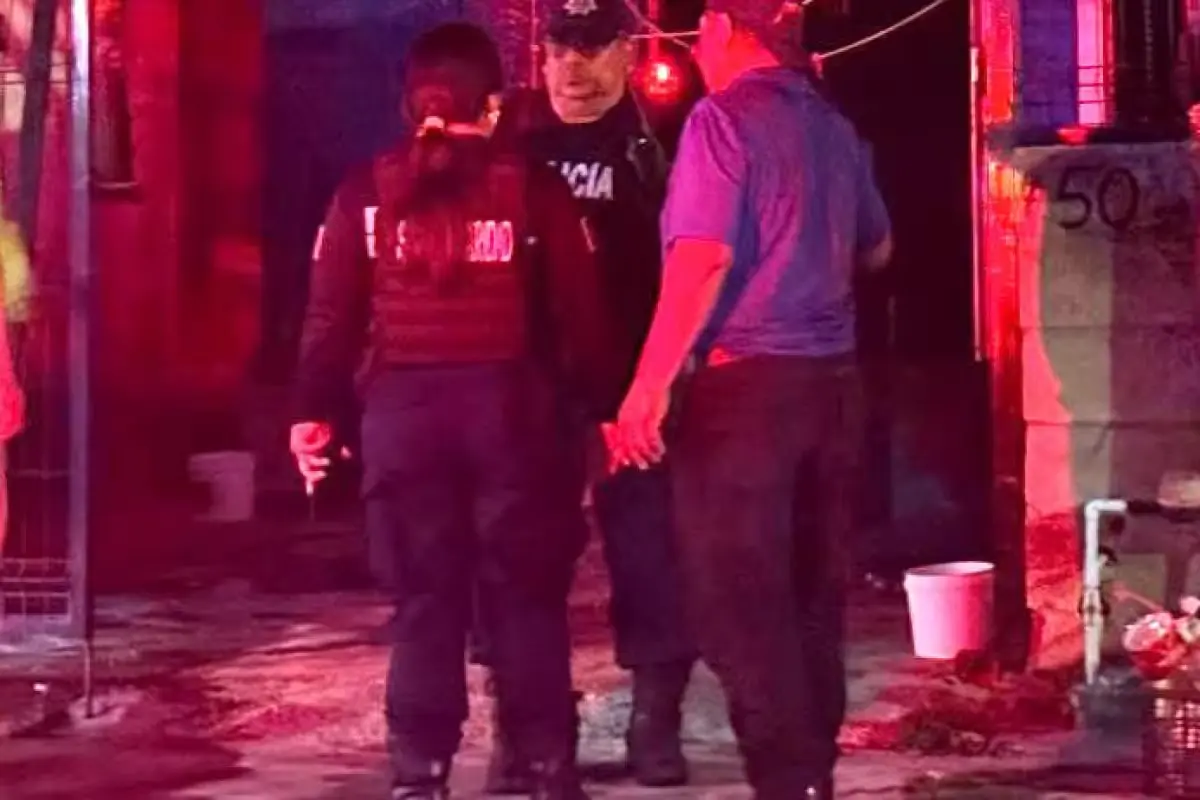 Emergency personnel and vehicles outside a house in Playa del Carmen after a fire set by a man who trapped his partner inside