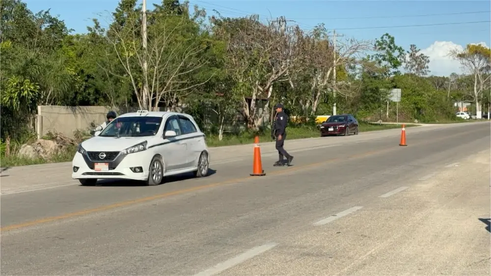 Police officers conducting vehicle inspections at a security checkpoint in Felipe Carrillo Puerto, Quintana Roo