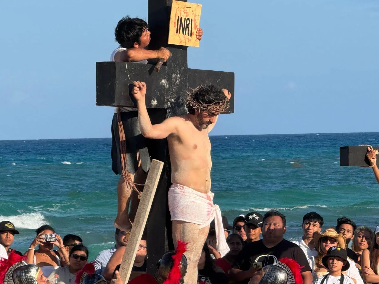 Participants gather on Delfines Beach in Cancun for a Good Friday Stations of the Cross procession.