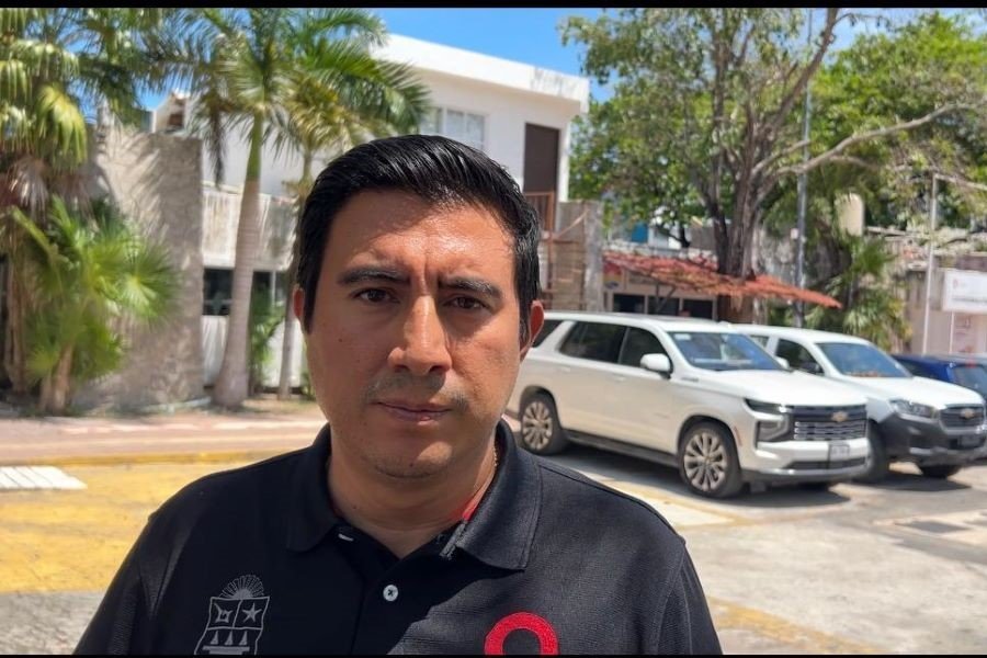 The head of Quintana Roo's mobility institute speaking to reporters outside a municipal building