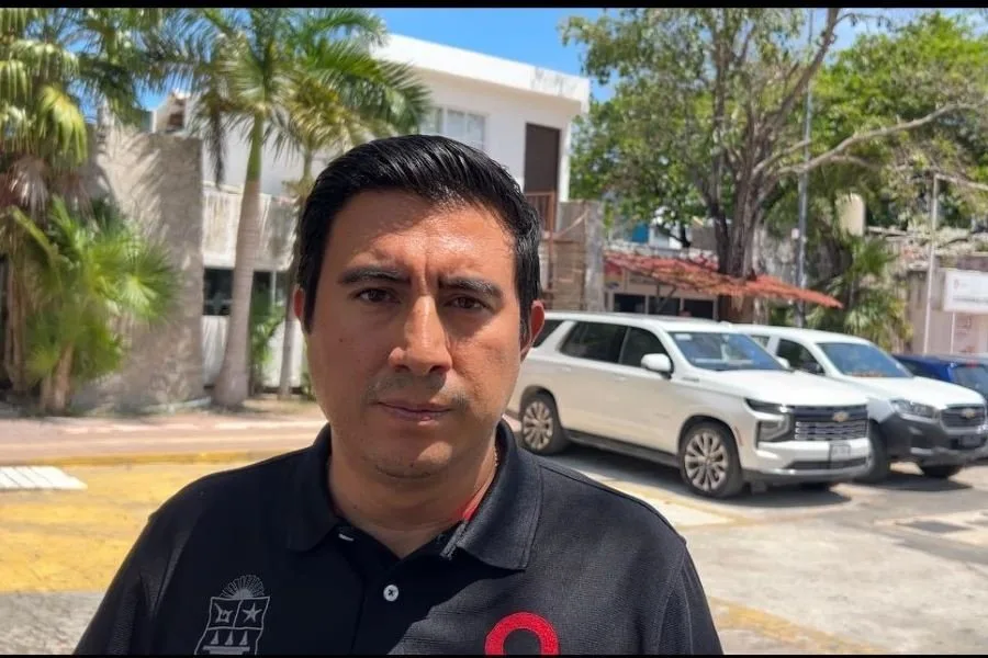 The head of Quintana Roo's mobility institute speaking to reporters outside a municipal building