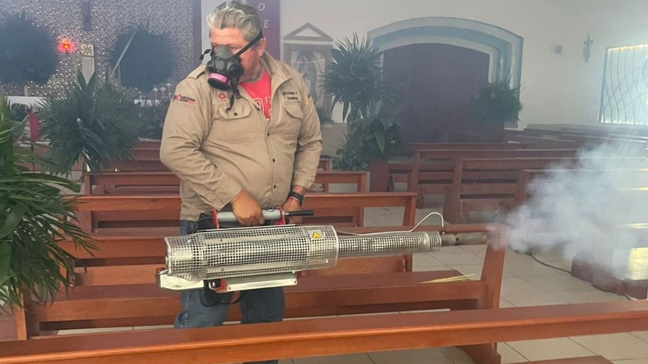 Workers fumigating a church interior in Isla Mujeres as part of mosquito control measures