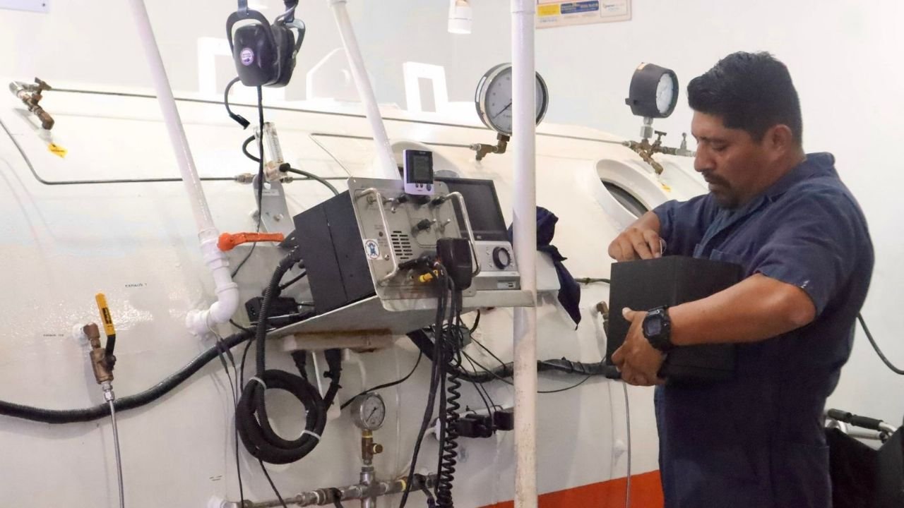 Technicians performing maintenance on the hyperbaric chamber at Isla Mujeres