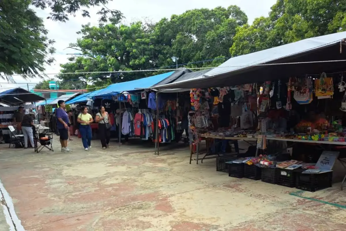A bustling street market scene in Mérida, Yucatán, with vendors and shoppers under colorful tarps