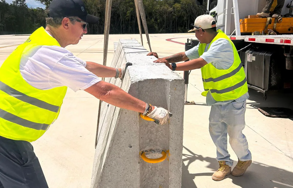 Construction workers assembling the oval track for the NASCAR Mexico Series at Tulum International Airport