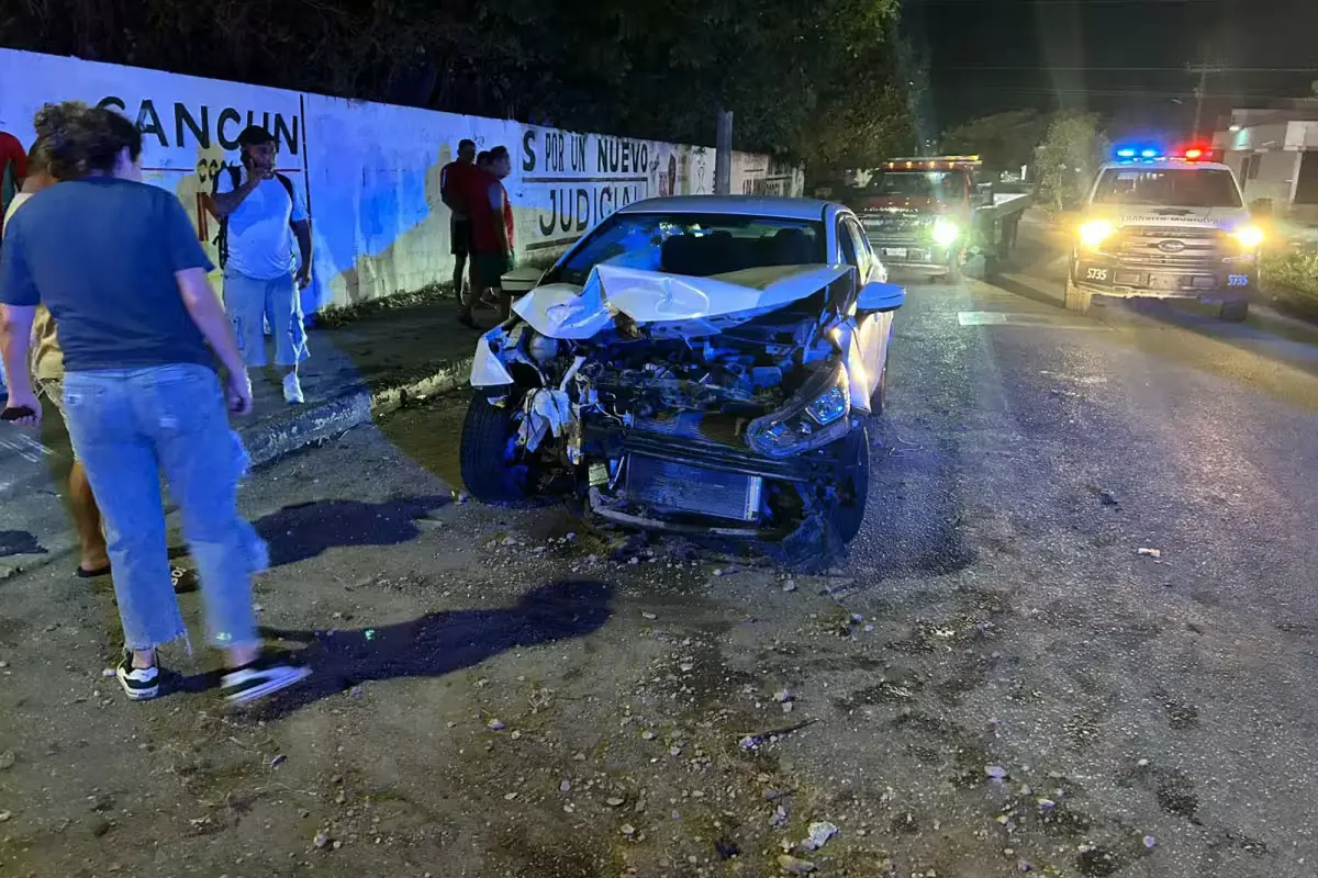 A white Nissan Versa with severe front-end damage after a collision in Cancún