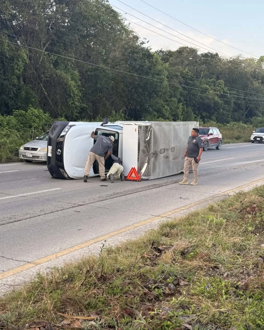 A Nissan cargo truck overturned on its side on Highway 307 near Caleta Tankah, Mexico