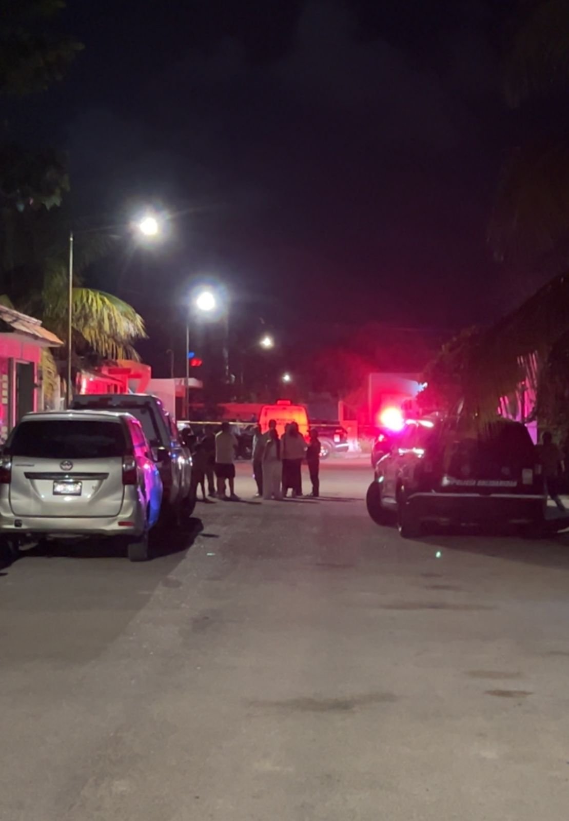 Police and forensic investigators at a backyard scene in Playa del Carmen